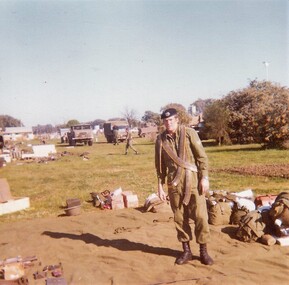 Soldier with belts of ammunition over shoulder.     