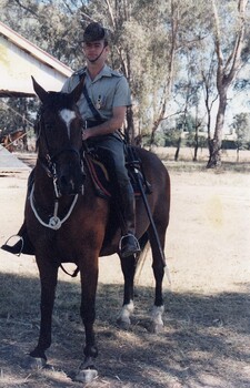 Soldier on horseback near trees