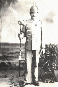Soldier in colonial military uniform with staff