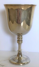 A silver goblet with stem with engraving round base.