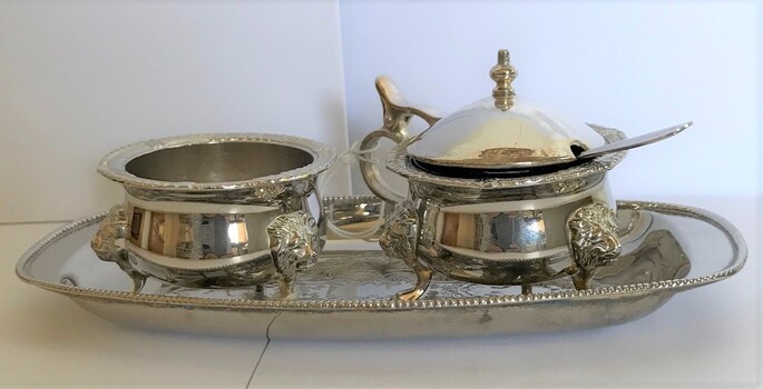Silver tray with a small bowl for mustard and a small bowl with spoon for salt.