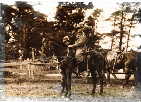 Soldier on horseback with another soldier standing near him