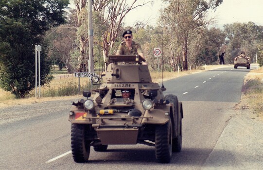 Scout car driving on road.