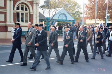 Ex- servicemen marching in city street.