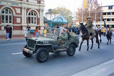 Jeep followed by soldier on a horse