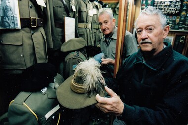Two men in museum, one holding a net