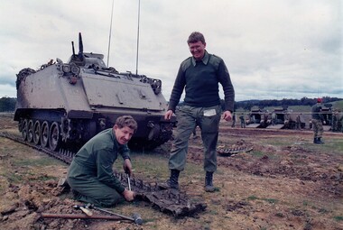 Two soldiers repairing a tank