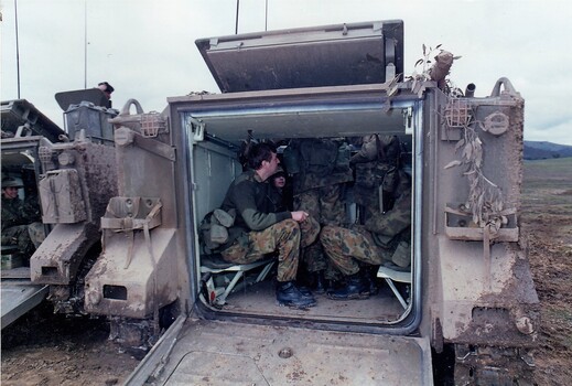 Soldiers sitting inside armoured carrier