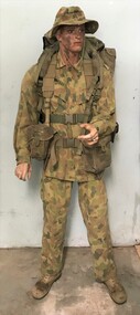 Soldier in camouflage uniform and with belt and pack