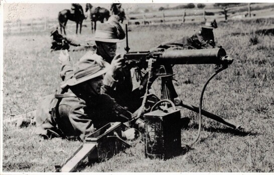 Two soldiers firing a machine gun
