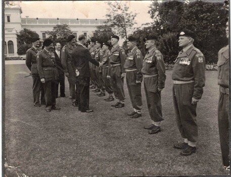 Soldiers at Government House meeting man in suit