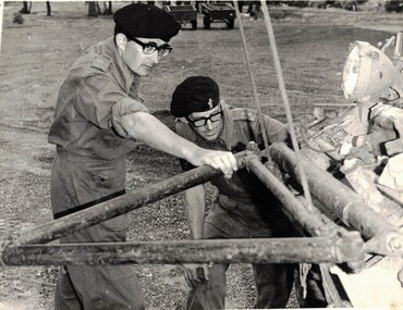 Two Army officers looking at vehicle