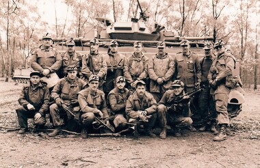 Group of soldiers beside tank.
