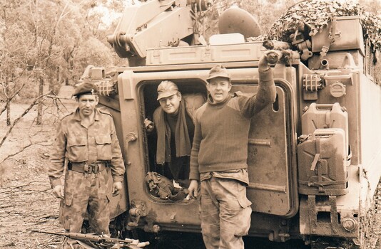 Three soldiers at rear of tank