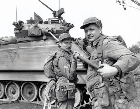 Two soldiers cleaning tank gun.
