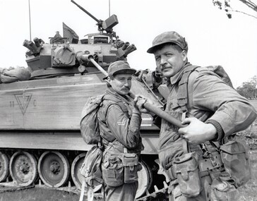 Two soldiers cleaning tank gun.