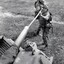 Two soldiers cleaning tank gun.