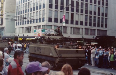 Soldiers in tank in city street.