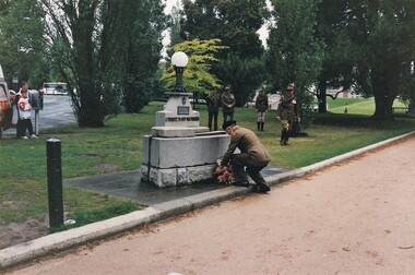 Soldier laying wreath at horse-trough memorial