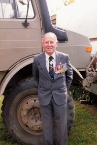 Former soldier standing beside truck