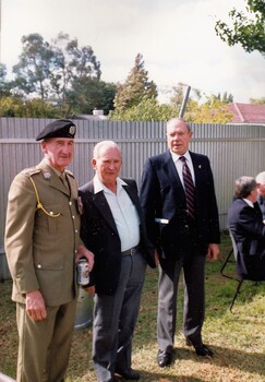 Soldier in uniform and two civilians