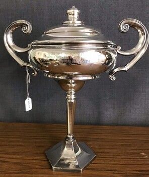 Silver cup with handles and engraving on side.