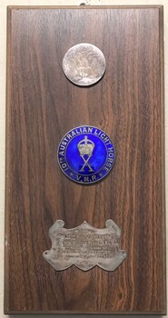 Stained board with badges and inscribed panel fixed to it.
