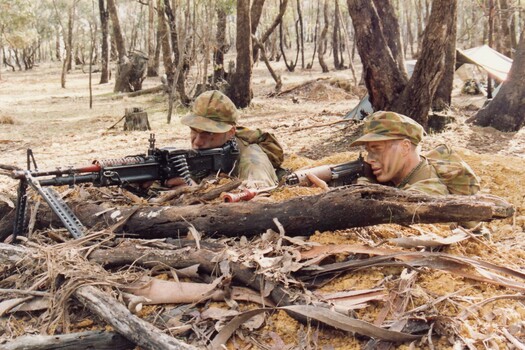 Two soldiers firing from weapon pit