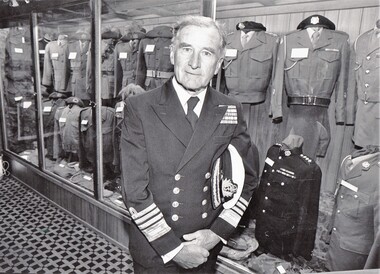 Naval officer standing in front of museum case.