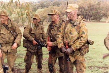 Four soldiers in camouflage uniform.