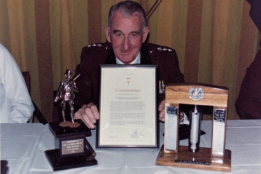 Army officer at table with 3 gifts.