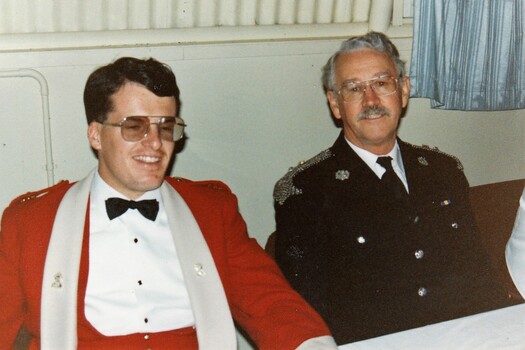 Two officers dress in formal uniforms.