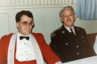 Two officers dress in formal uniforms.