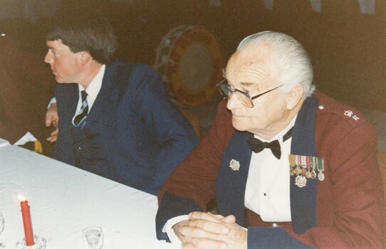 Civilian sitting next to officer in formal uniform