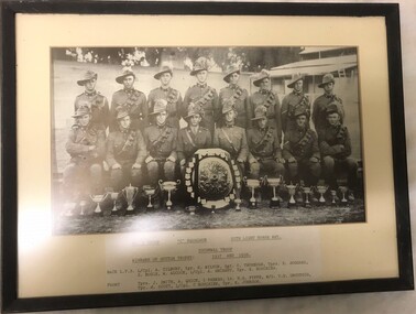 Group of soldiers posed with shield and trophies.