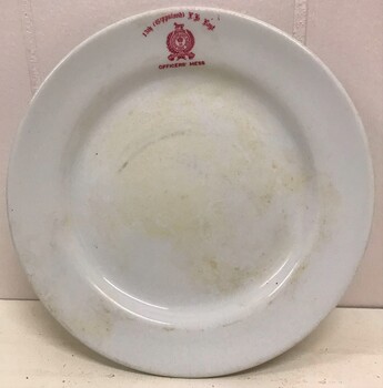 Crockery plate with monogram on edge.