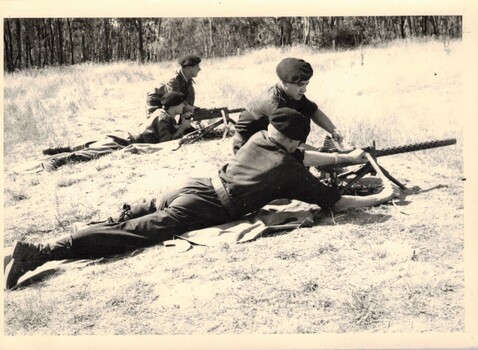 Two soldiers firing machine gun at range.