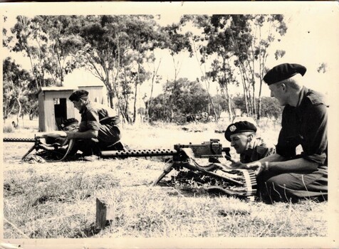 Two pairs of soldiers firing machine guns. 