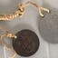 Two small metal objects with writing stamped on them.