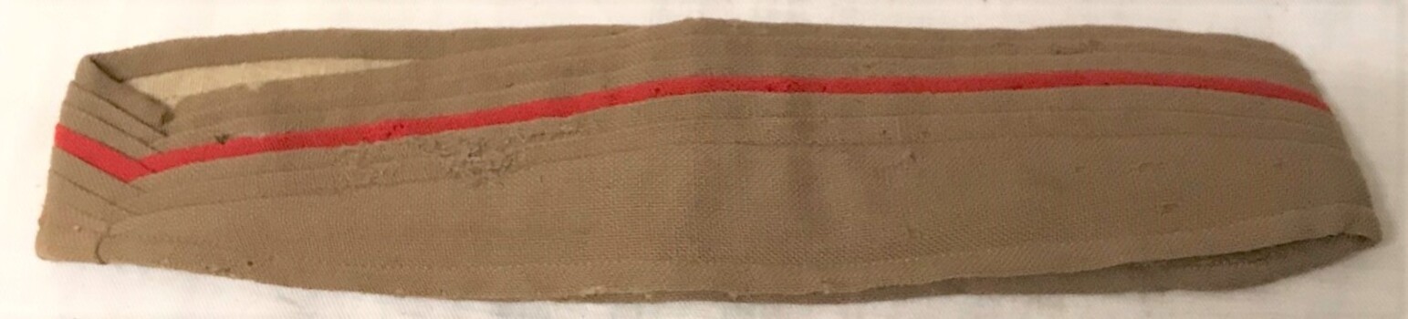 Cloth hat band with red stripe.