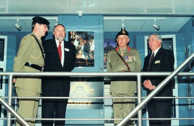 Two soldiers and two civilians on dais