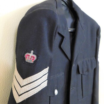 Jacket sleeve with embroidered crown over silver stripes.