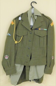 Khaki uniform with badges on jacket.