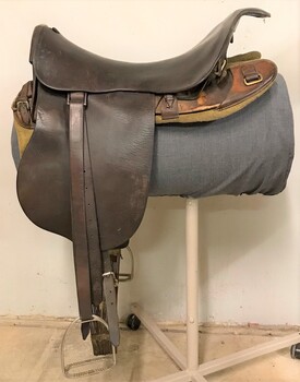 Leather riding saddle placed on a metal stand