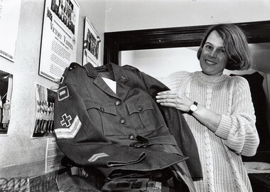 Lady holding an old Army uniform