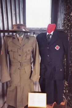 Two army uniforms on display in shed