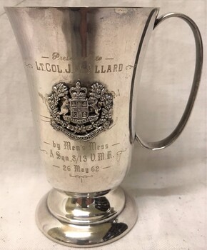 Silver drinking mug with badge on side.