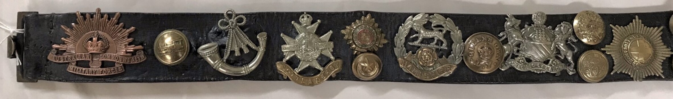 Portion of belt with badges on it.