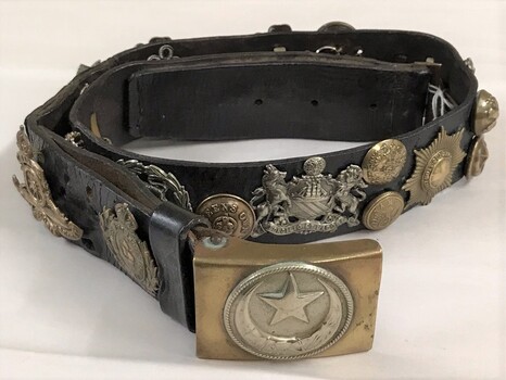 Leather belt with badges attached to it