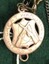 Small gold medallion with lettering both sides